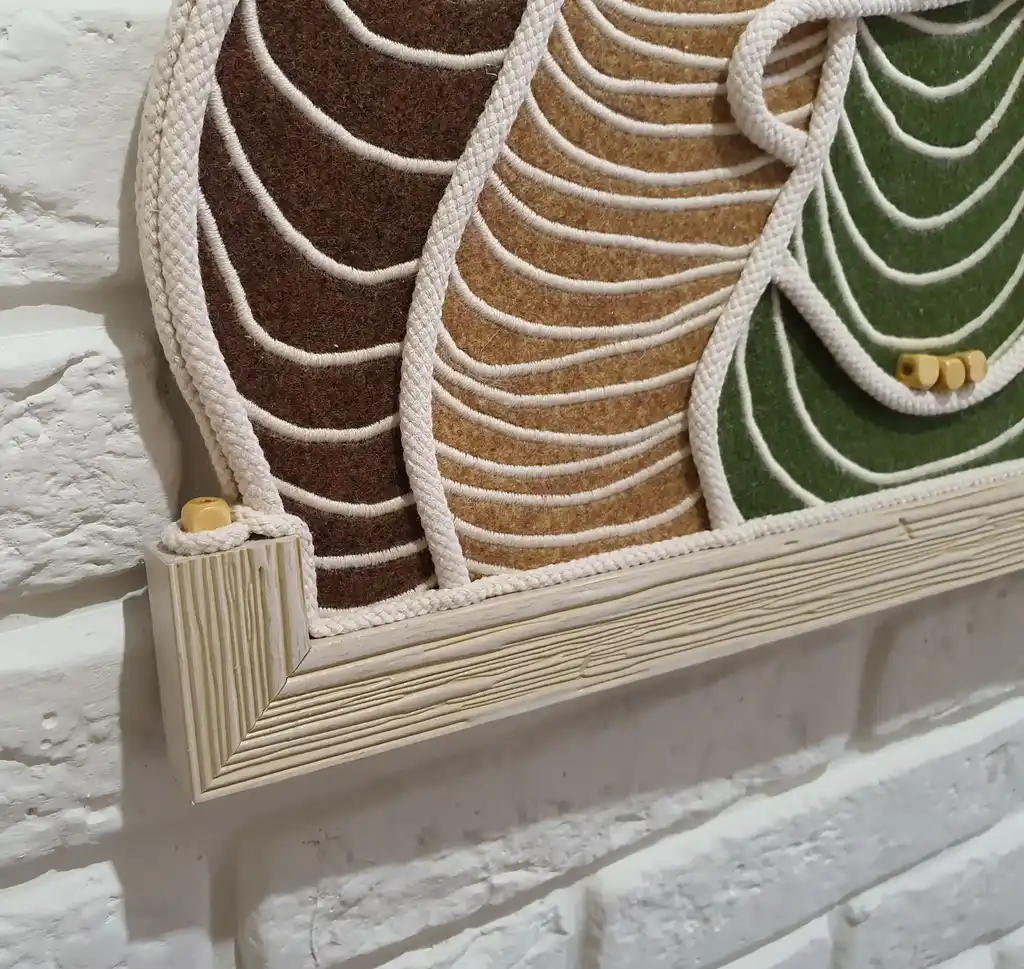 handmade embroidered wall hanging made from felt with rope and beech wood accents.