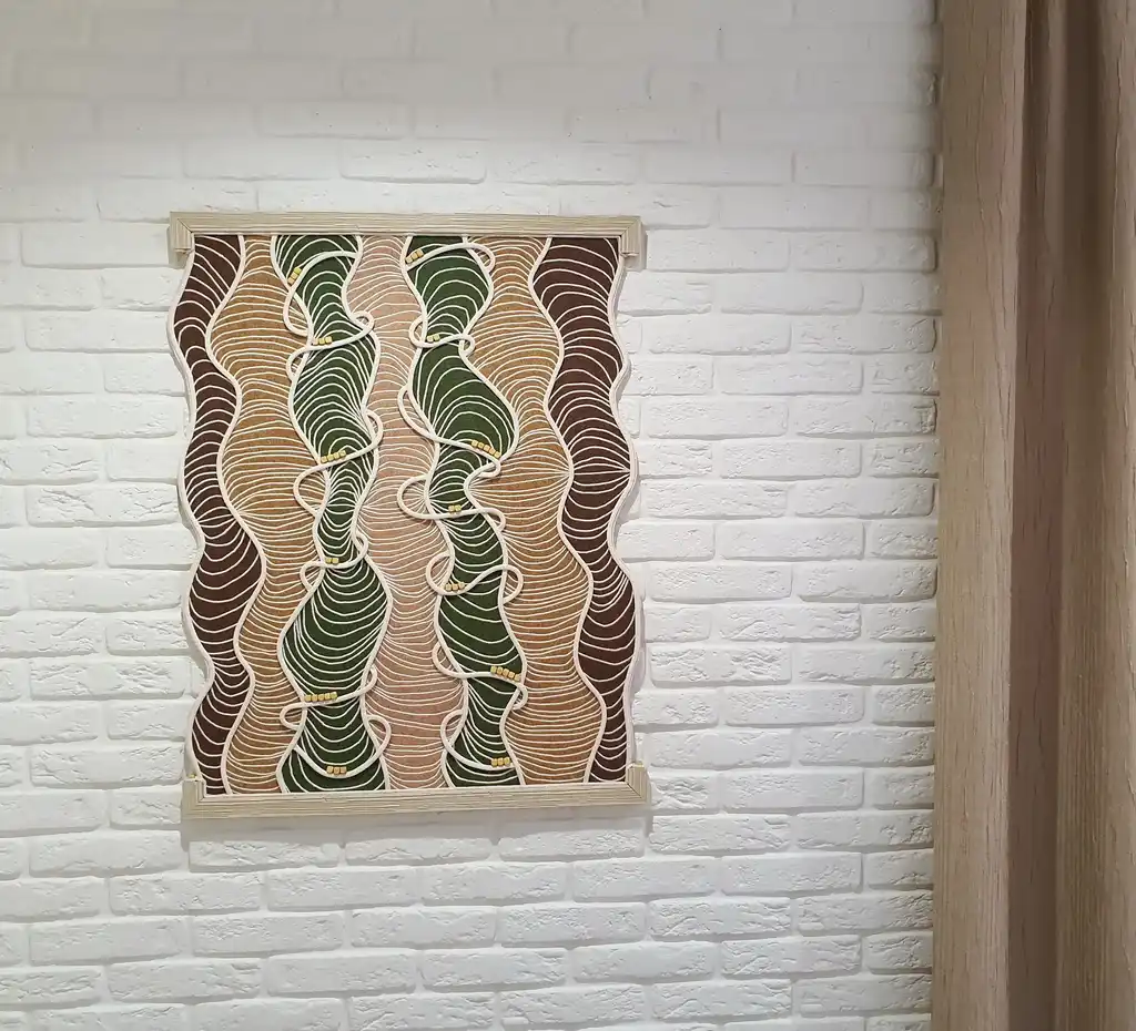 handmade embroidered wall hanging made from felt with rope and beech wood accents.