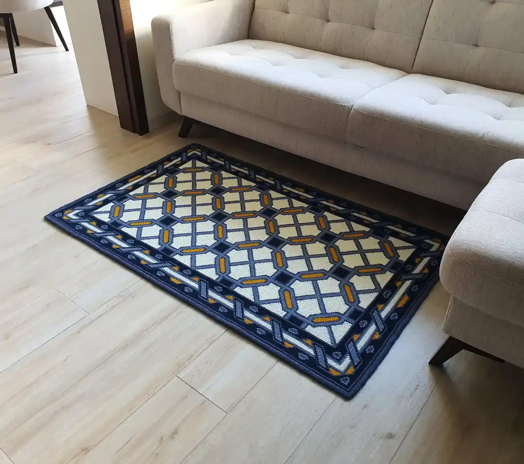handcrafted wool rug with cross-stitch pattern.