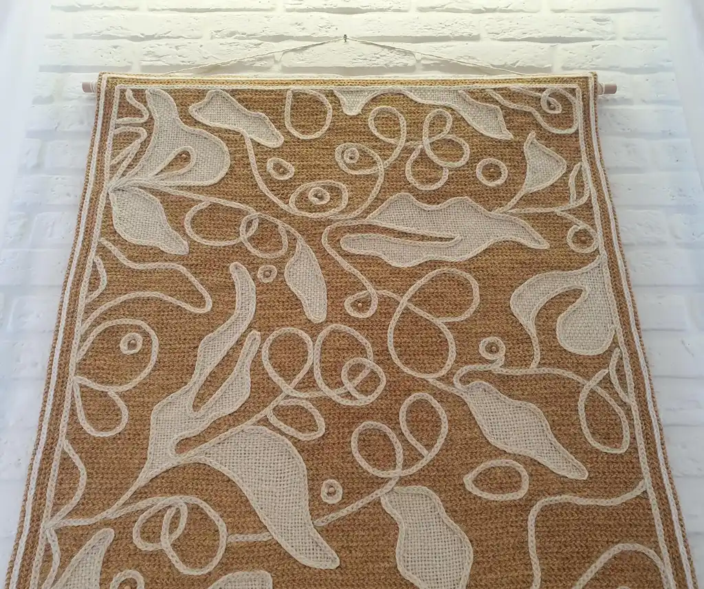 handmade cross-stitch wall hanging tapestry made from wool and jute materials.