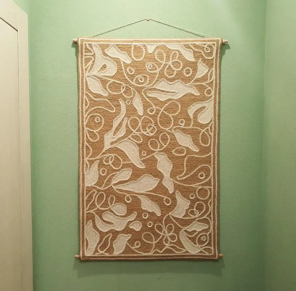 handmade cross-stitch wall hanging tapestry made from wool and jute materials.