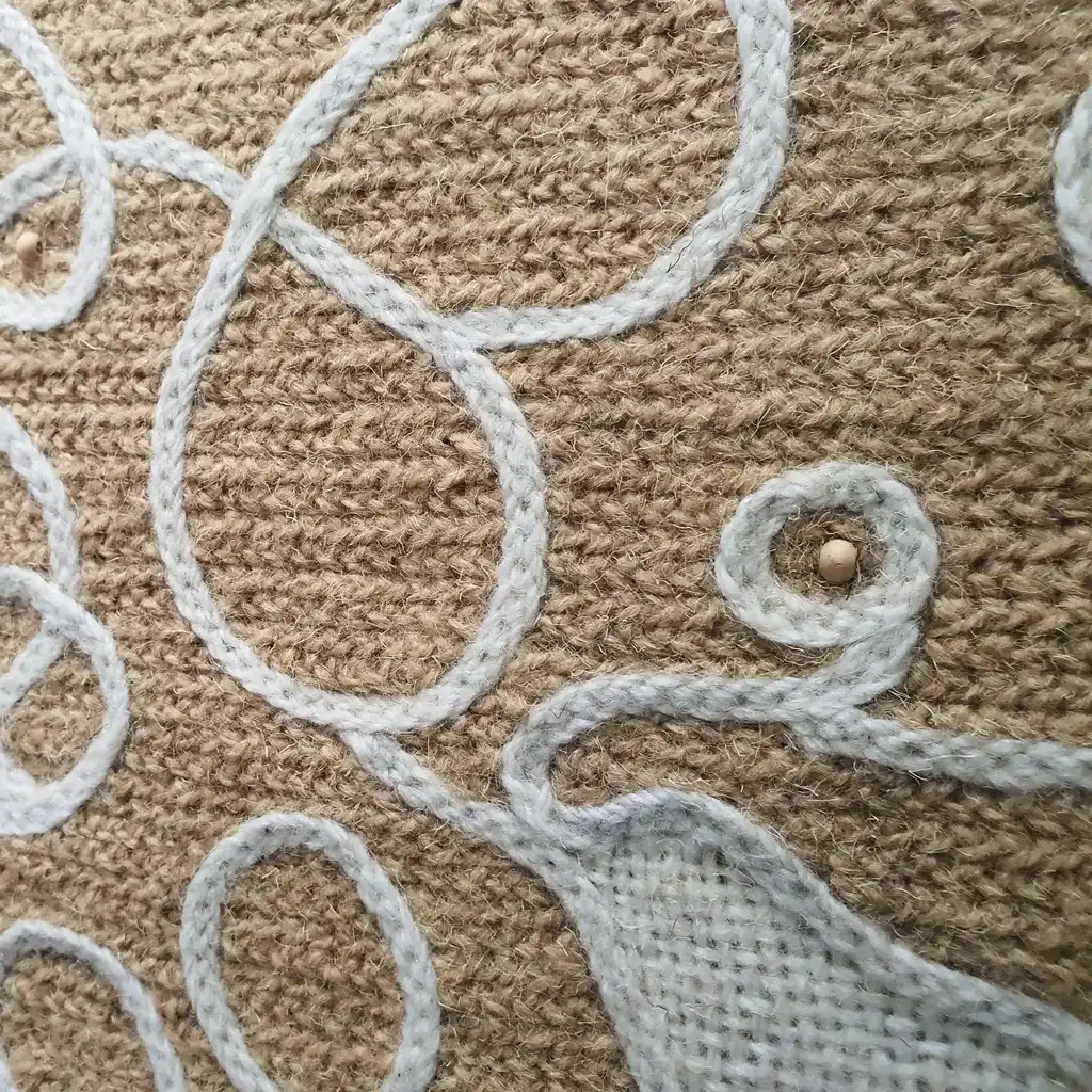 handmade cross-stitch wall hanging tapestry made from wool and jute materials.
