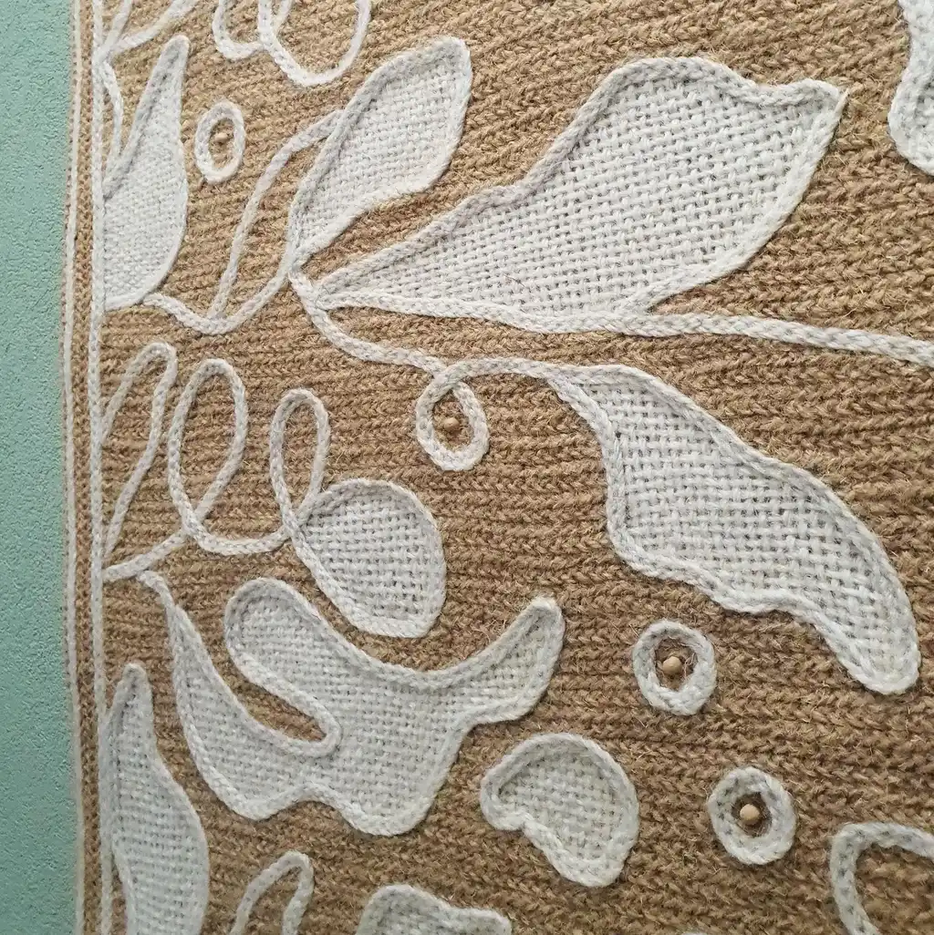 handmade cross-stitch wall hanging tapestry made from wool and jute materials.