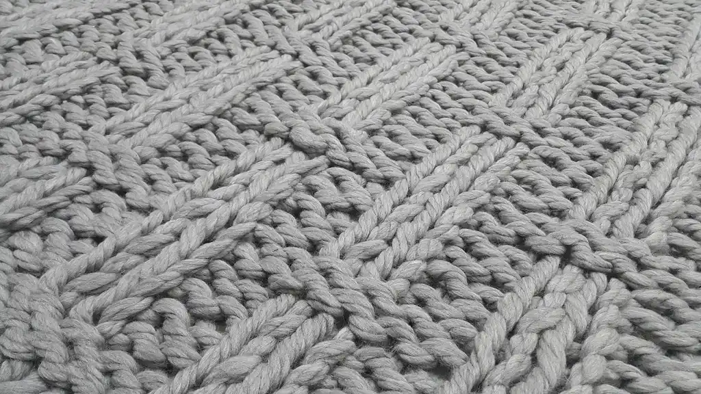 chunky wool knitted blanket in neutral color, handcrafted throw for home comfort.