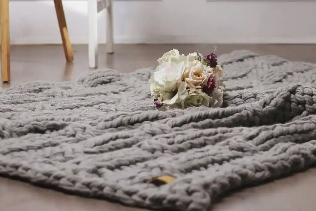 chunky wool knitted blanket in neutral color, handcrafted throw for home comfort.