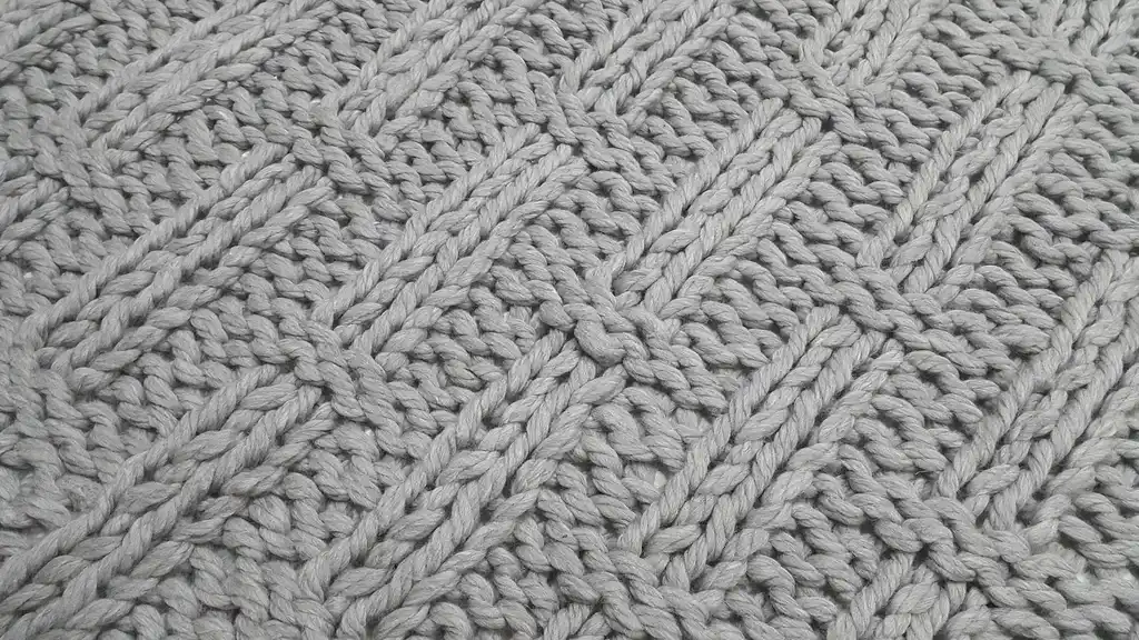 chunky wool knitted blanket in neutral color, handcrafted throw for home comfort.