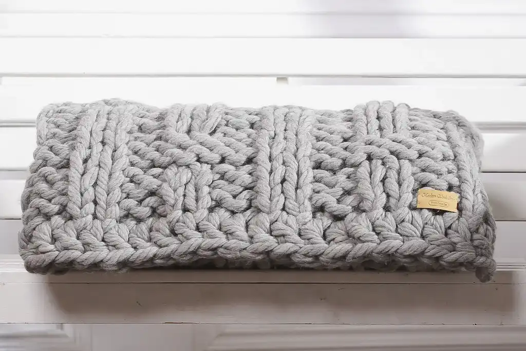 chunky wool knitted blanket in neutral color, handcrafted throw for home comfort.