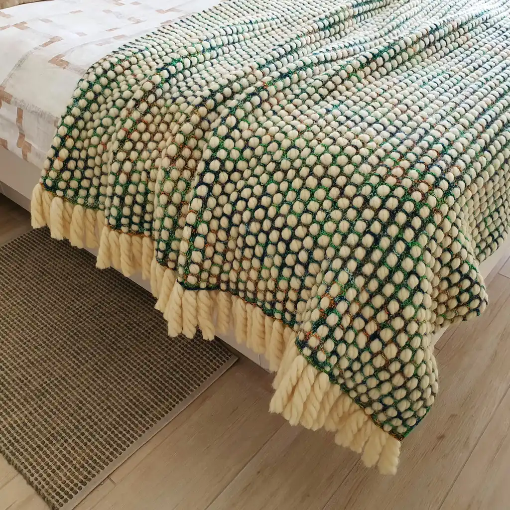 Luxurious chunky wool crochet blanket with intricate handmade patterns in neutral tones.