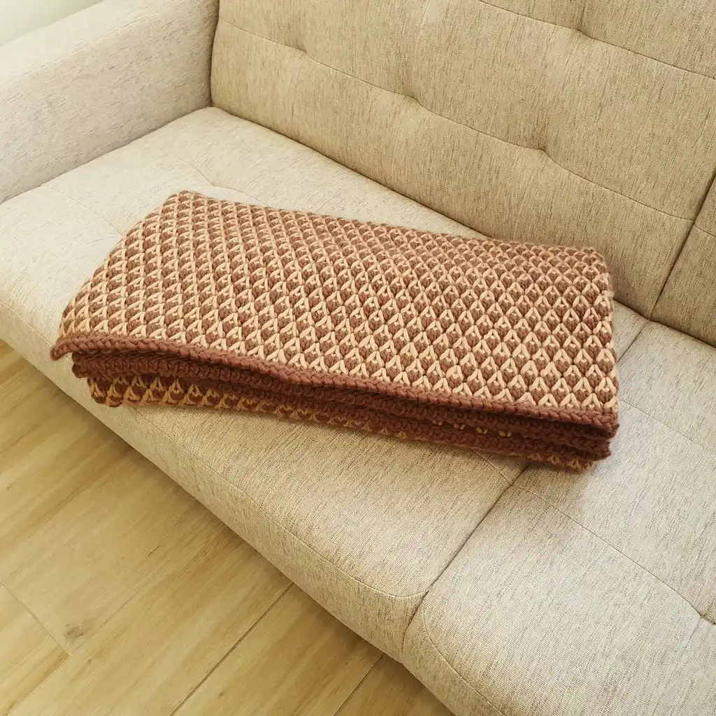 The luxury merino wool knitted throw blanket in elegant design.