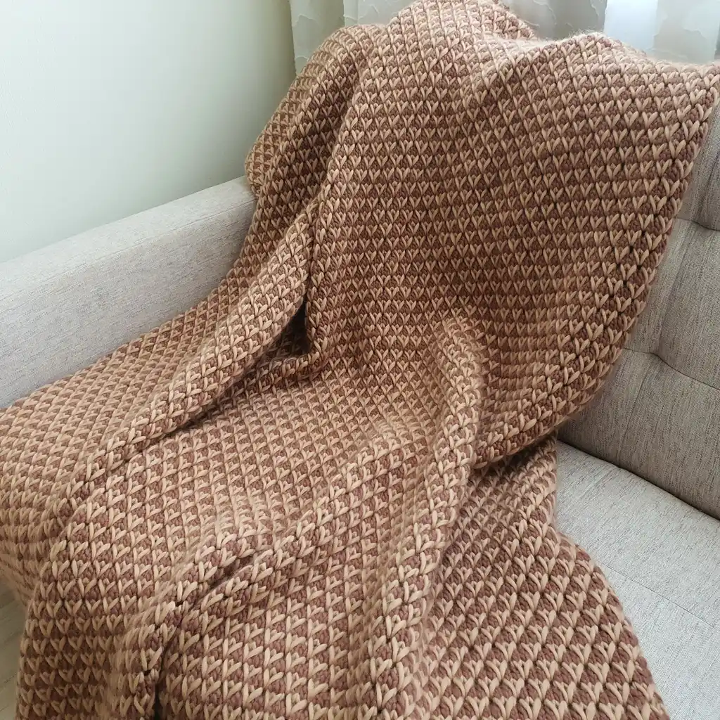 The luxury merino wool knitted throw blanket in elegant design.