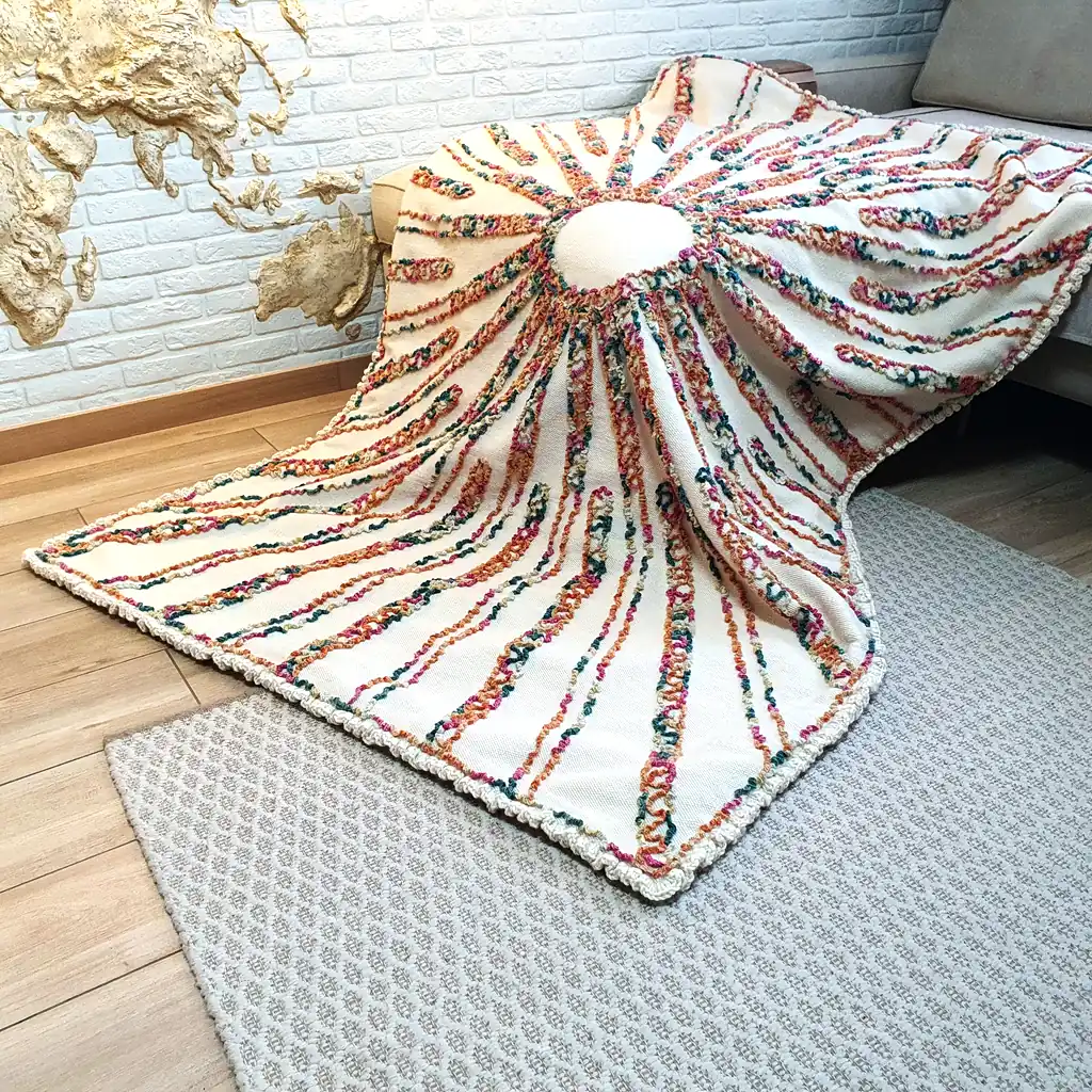 Boho-style wool throw blanket with sun-inspired embroidered design.