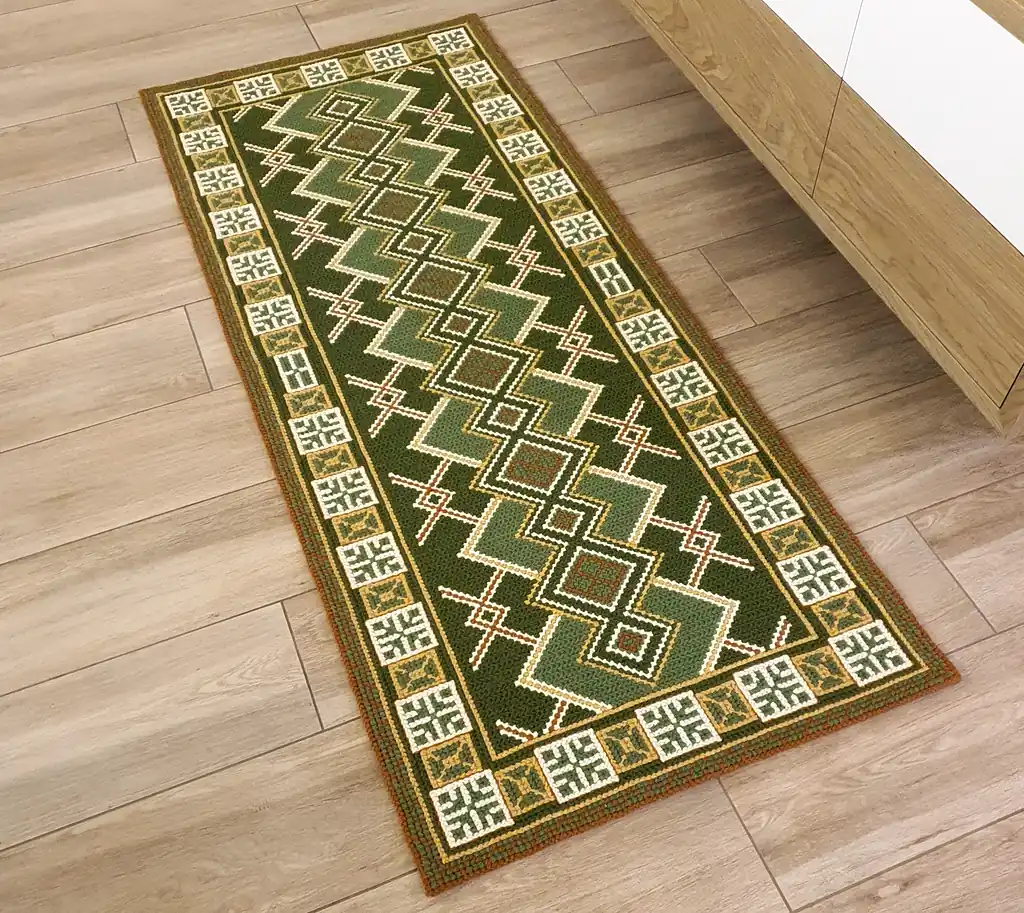 Handmade wool runner rug with authentic Ukrainian ethnic ornament, featuring green and earthy tones, lying on a light wood floor in a modern interior.