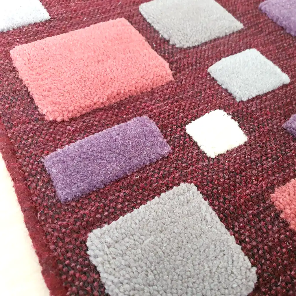 Cozy bedroom decor featuring a deep burgundy handwoven wool rug. Sustainable home accent that adds warmth and artistic character to a Scandi or Boho room.