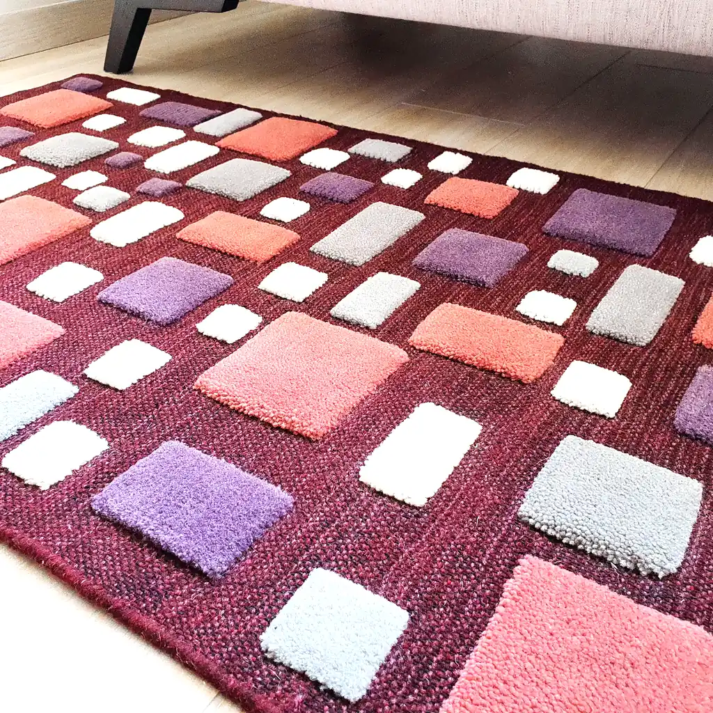Cozy bedroom decor featuring a deep burgundy handwoven wool rug. Sustainable home accent that adds warmth and artistic character to a Scandi or Boho room.