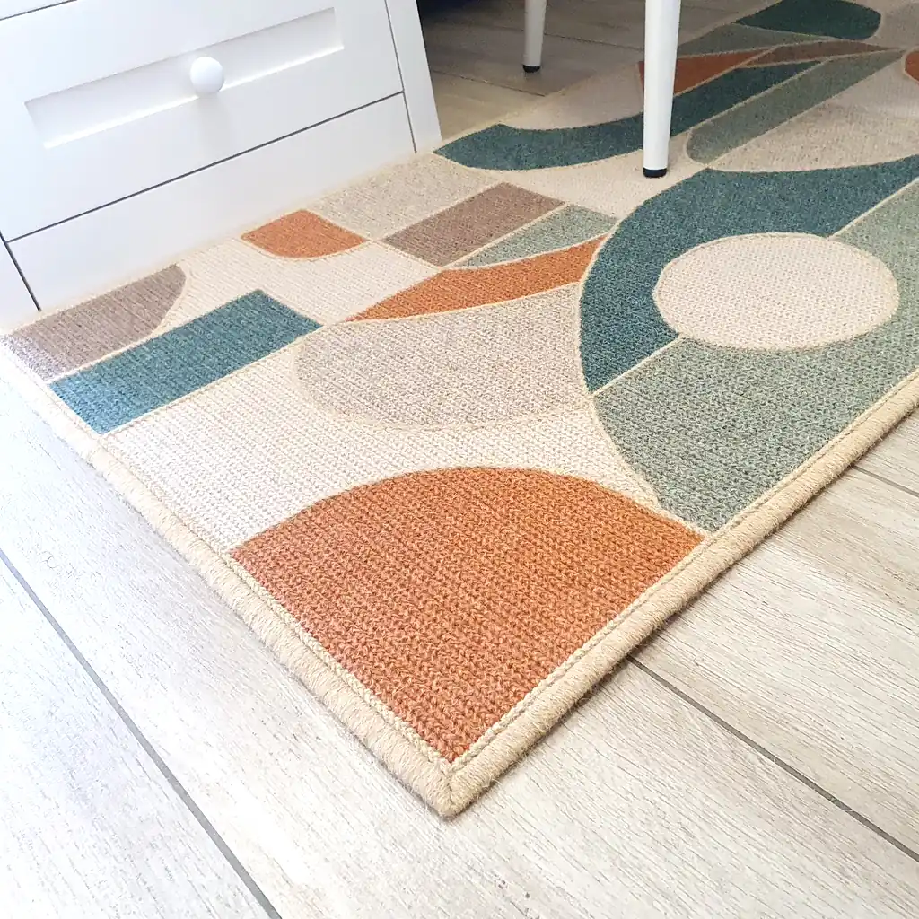 Handmade embroidered wool rug with geometric mosaic pattern in teal, orange, and cream colors with thick plush lining and natural jute border