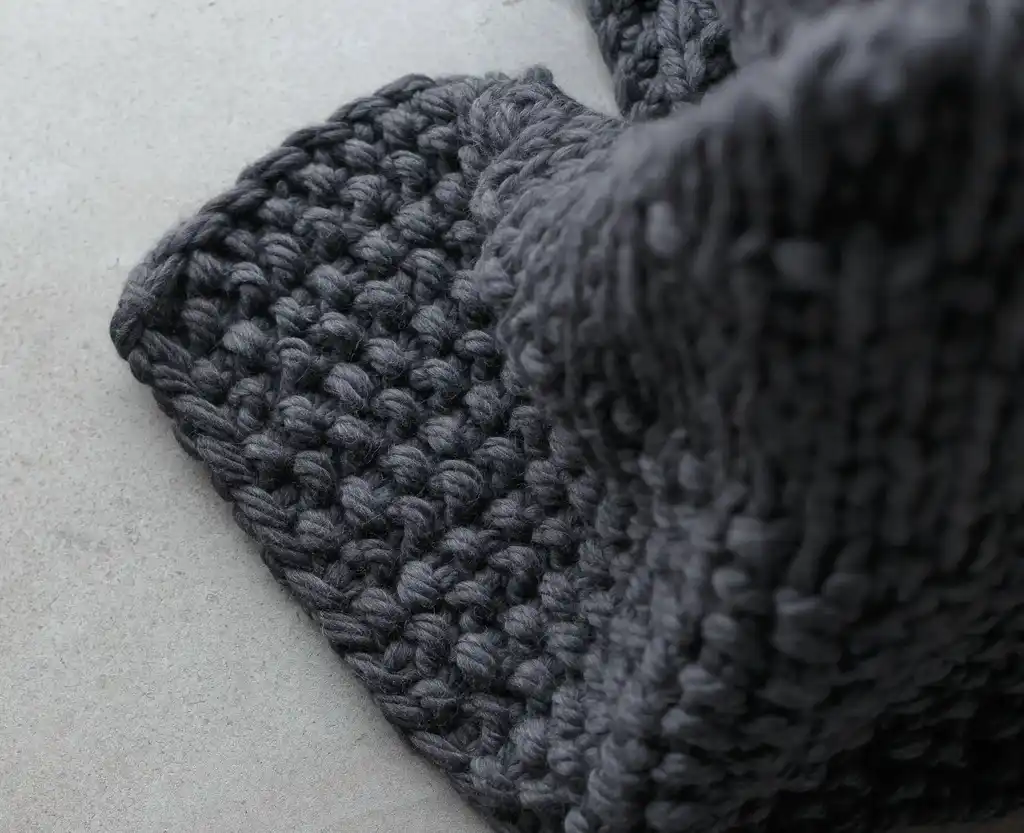chunky wool knit blanket in natural tones, handcrafted traditional knitting.