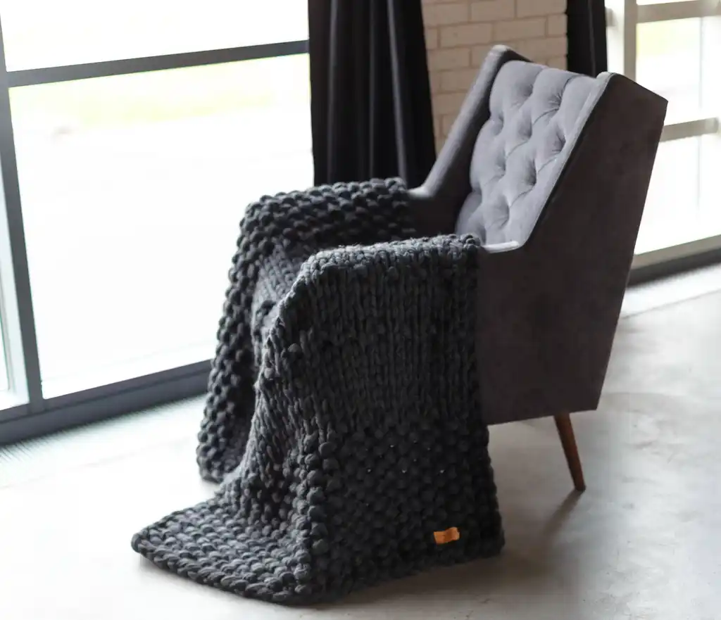 chunky wool knit blanket in natural tones, handcrafted traditional knitting.