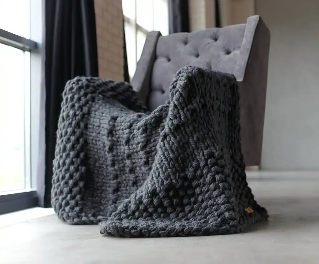 chunky wool knit blanket in natural tones, handcrafted traditional knitting.