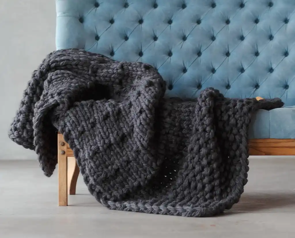 chunky wool knit blanket in natural tones, handcrafted traditional knitting.