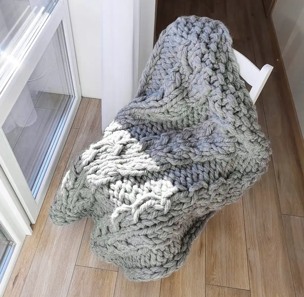 chunky wool knitted blanket in neutral color, handcrafted cozy throw for home comfort.