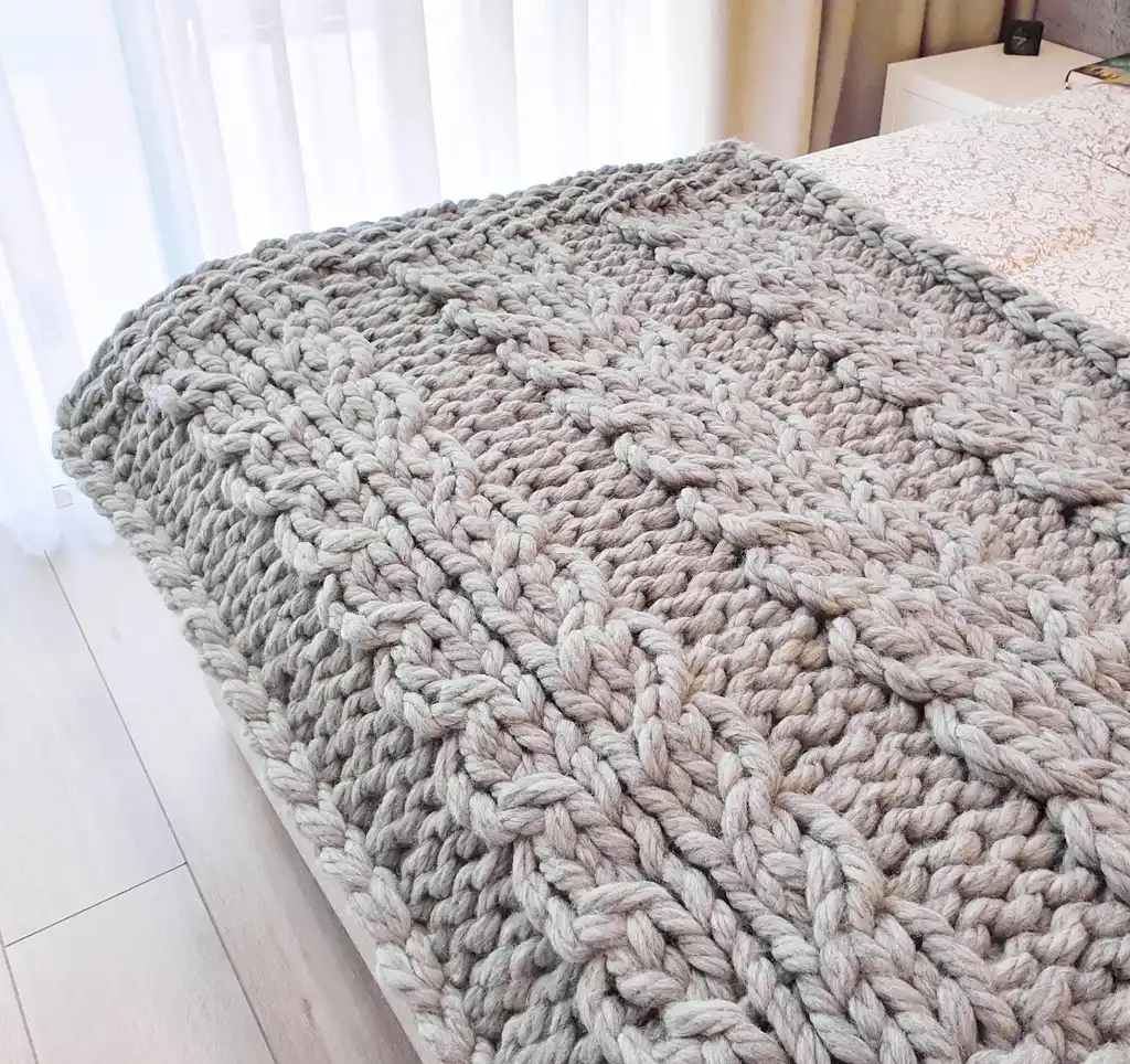 chunky wool knitted blanket in neutral color, handcrafted cozy throw for home comfort.