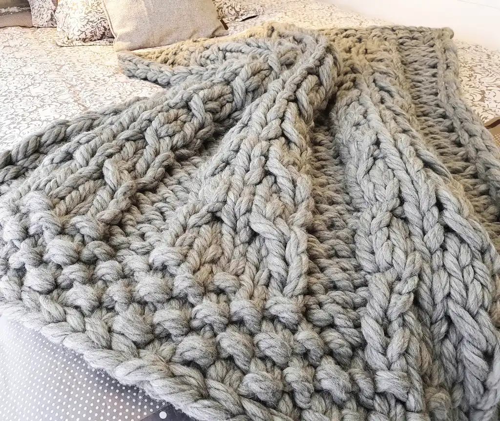 chunky wool knitted blanket in neutral color, handcrafted cozy throw for home comfort.