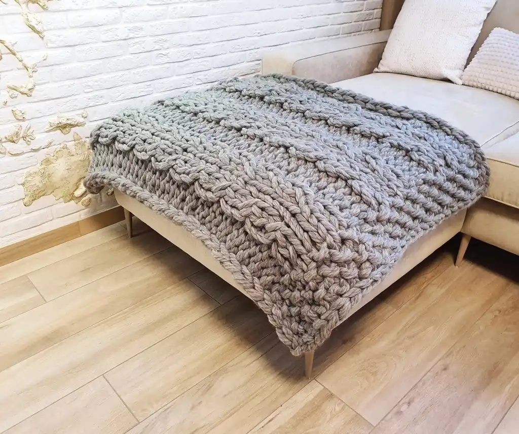 chunky wool knitted blanket in neutral color, handcrafted cozy throw for home comfort.