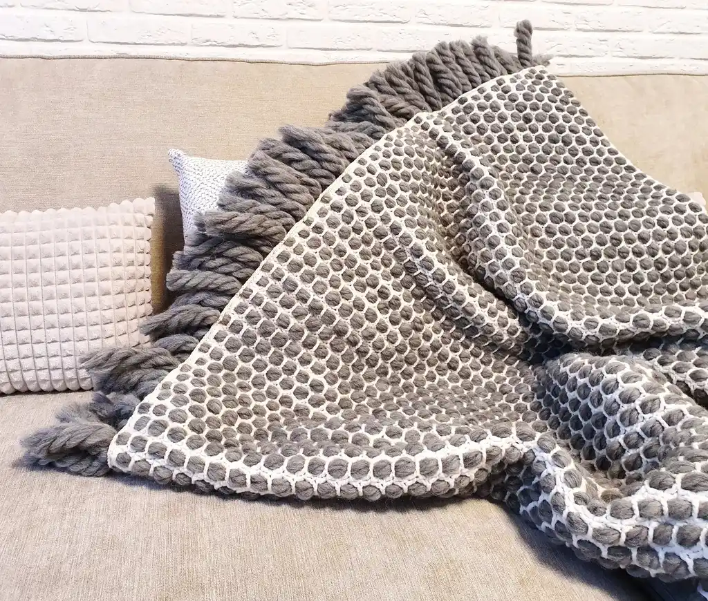 handmade crochet blanket made from chunky merino wool in natural color.