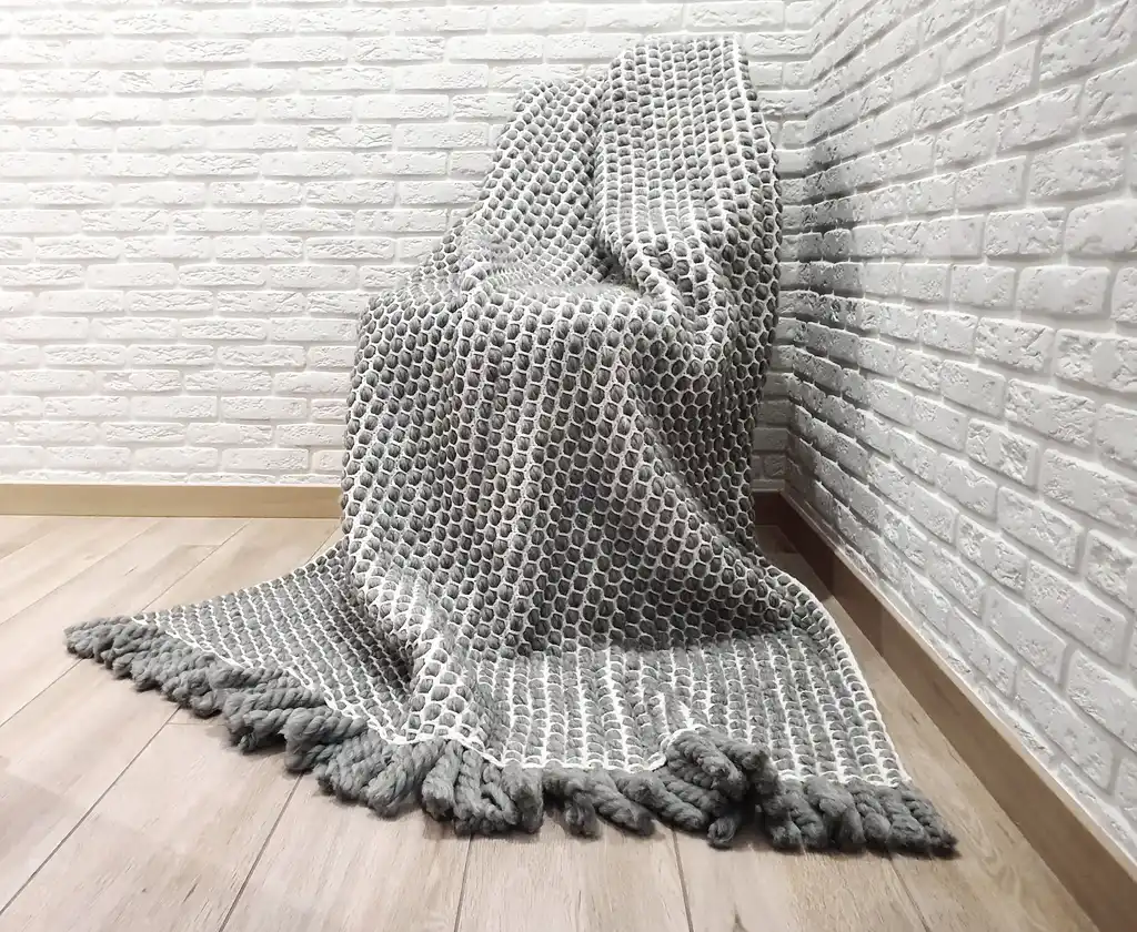 handmade crochet blanket made from chunky merino wool in natural color.