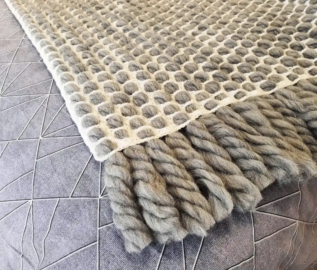 handmade crochet blanket made from chunky merino wool in natural color.