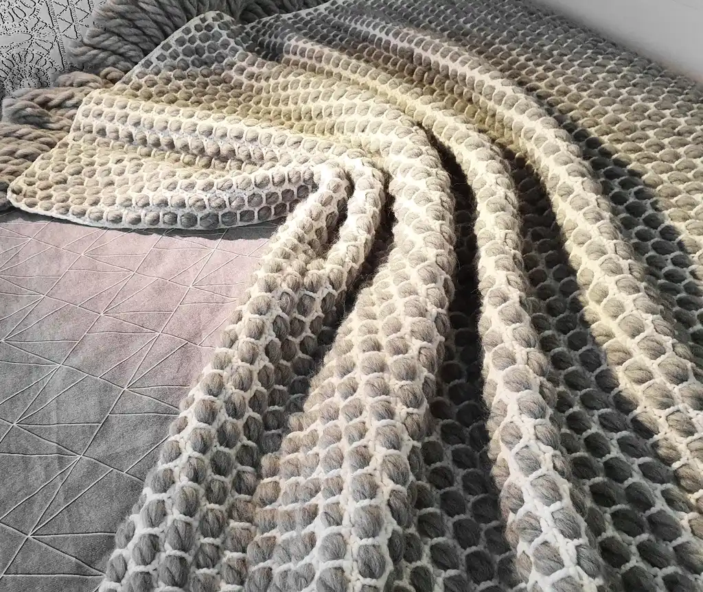 handmade crochet blanket made from chunky merino wool in natural color.