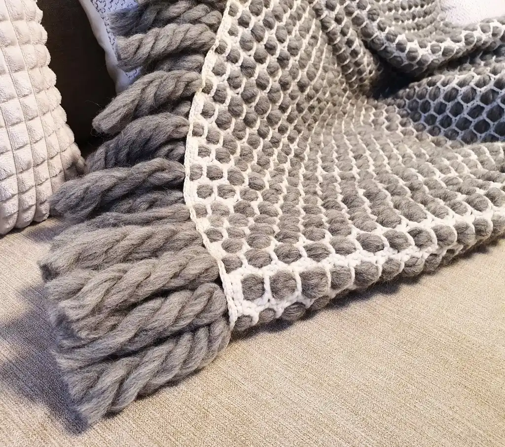 handmade crochet blanket made from chunky merino wool in natural color.