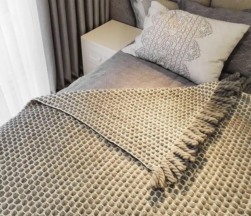 handmade crochet blanket made from chunky merino wool in natural color.