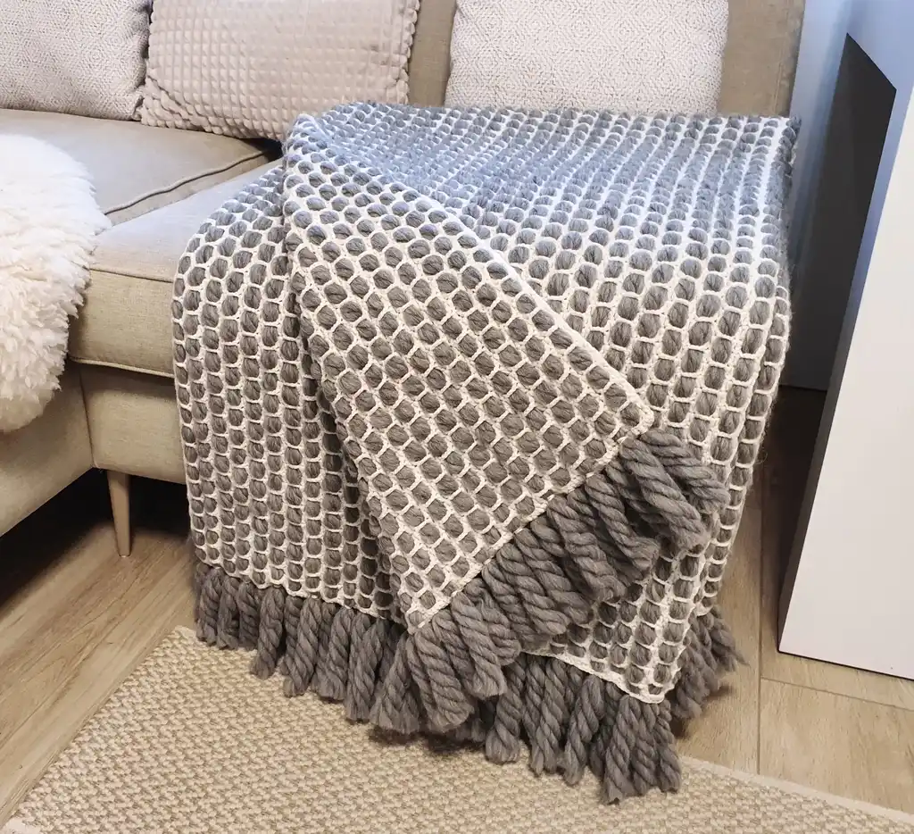 handmade crochet blanket made from chunky merino wool in natural color.