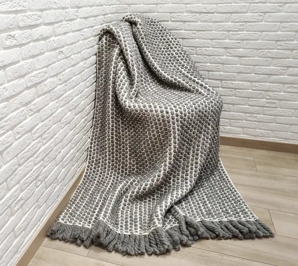 handmade crochet blanket made from chunky merino wool in natural color.