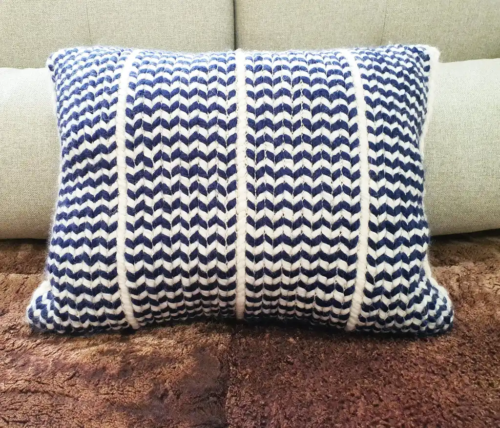 Crochet wool cushion in neutral tones, decorative home accent piece.
