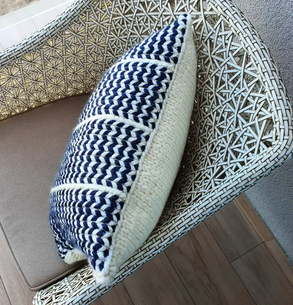 Crochet wool cushion in neutral tones, decorative home accent piece.