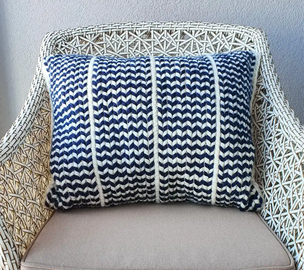 Crochet wool cushion in neutral tones, decorative home accent piece.