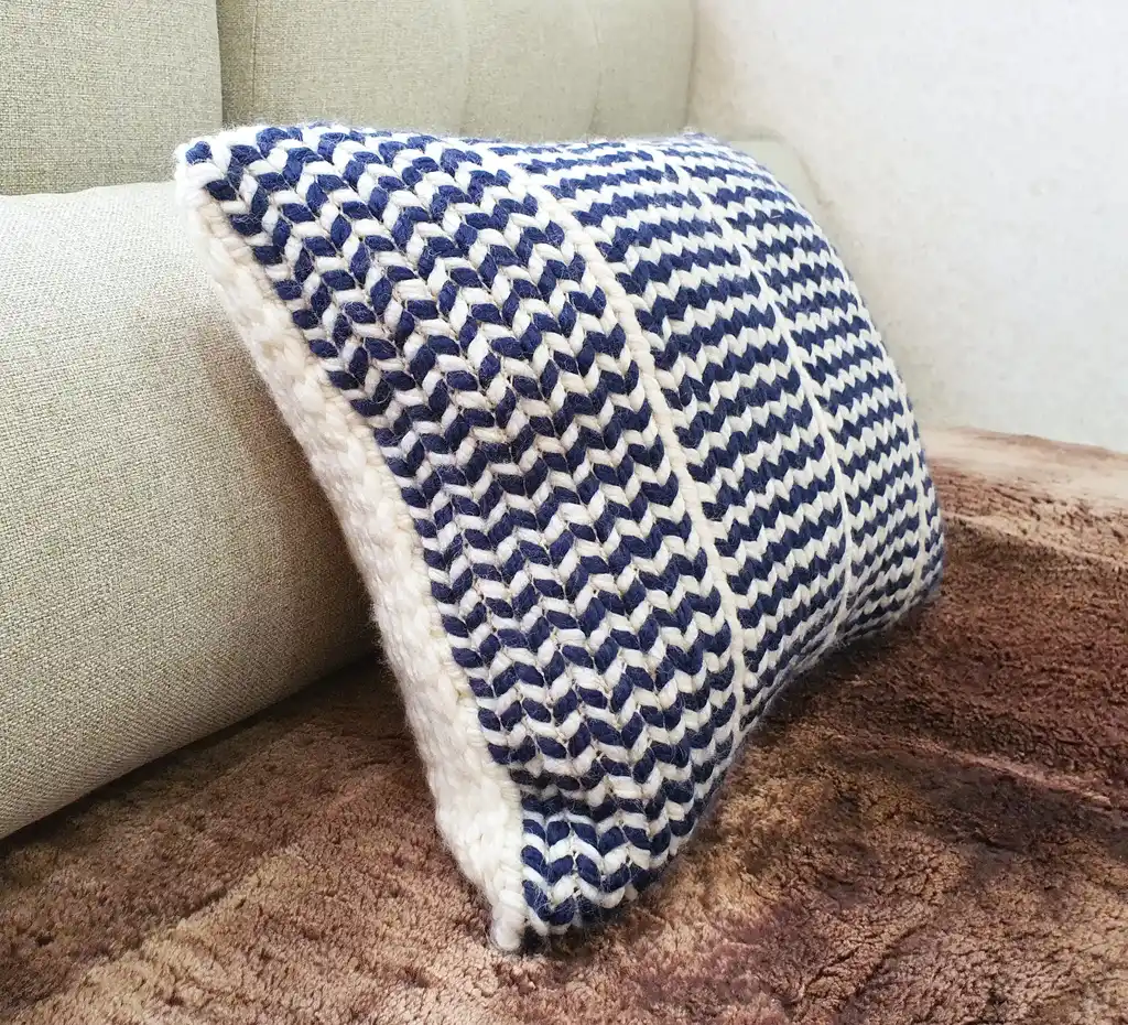 Crochet wool cushion in neutral tones, decorative home accent piece.